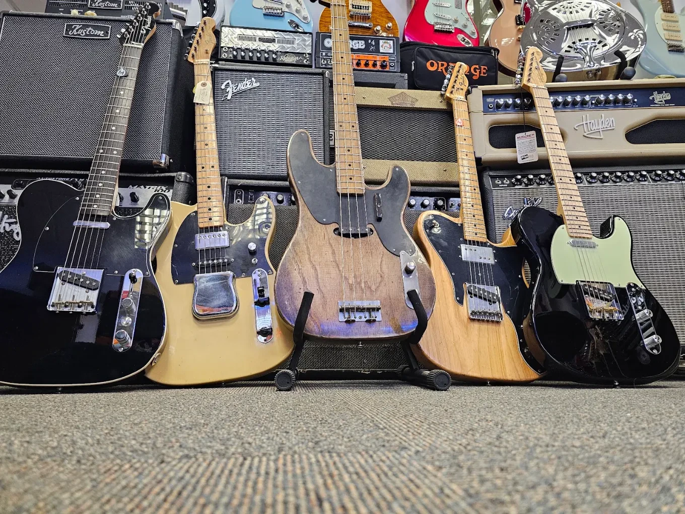 Guitar wall at Marshland Guitars — electric guitars and amps on display